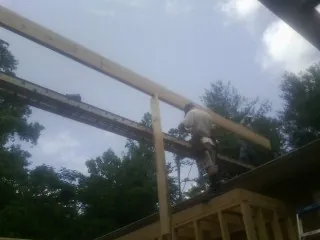 Carpenter setting a ridge beam over a new addition frame — Ice Dam Removal by Roofing Brothers in Buena Vista
